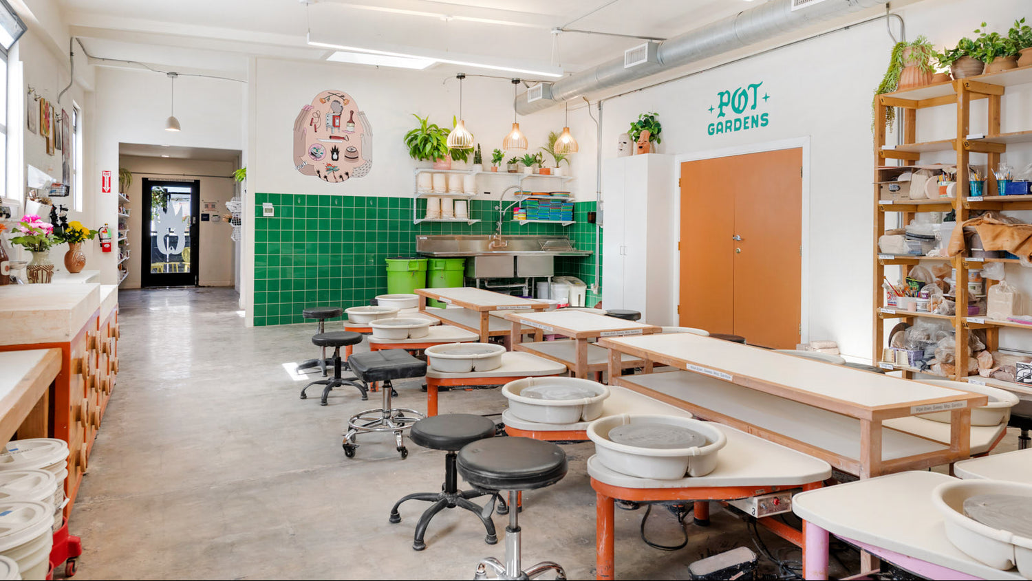 Wheel Throwing area with green walls, wooden counters, and various pottery equipment.