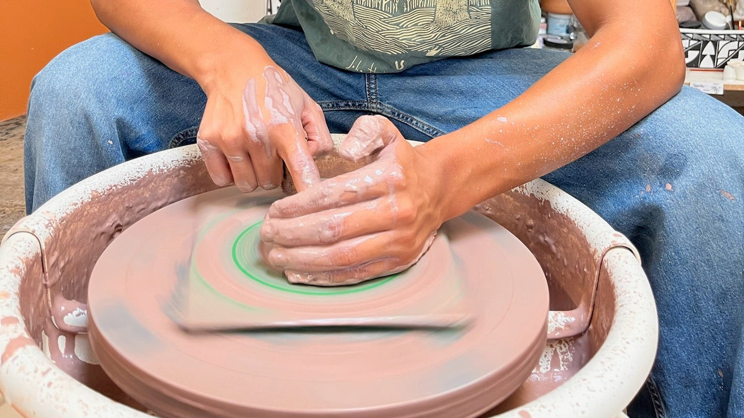 A teen working on a pottery wheel in POT Gardens