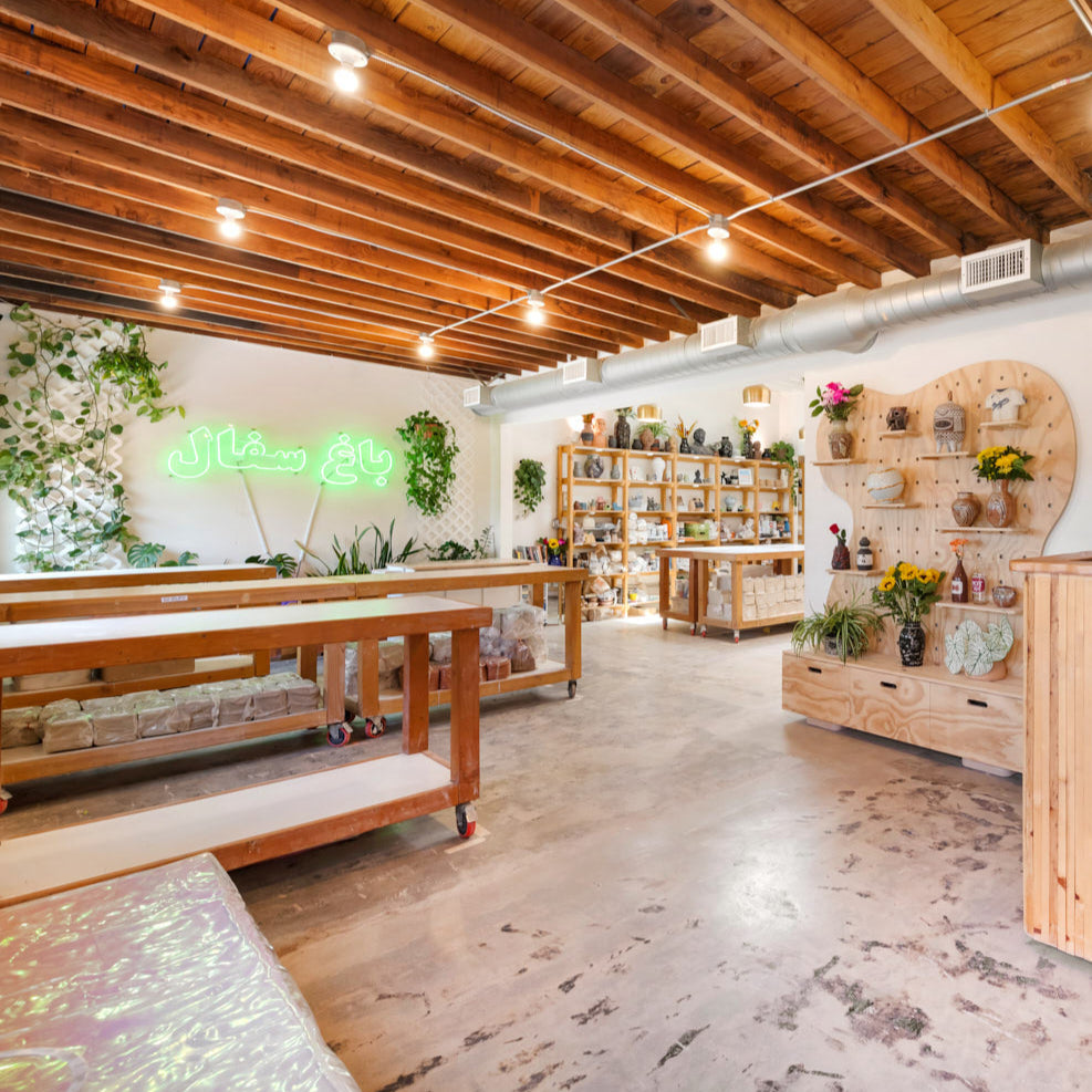 Interior of a POT Gardens with wooden decor, shelves, and a counter.